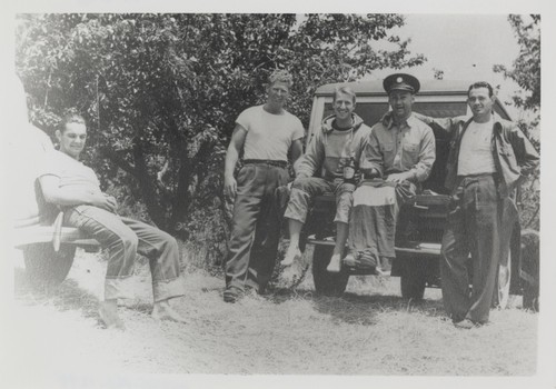 Bob Sutter, Clyde Hartman, Fred Hunt, E. J. Oshier, P. B. "Smitty" Smith sitting on automobiles