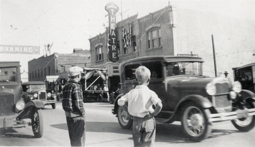 Two boys and automobiles on Ramsey Street in Banning, California during the Colorado River Aqueduct celebration