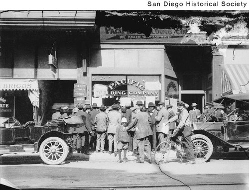 Group of men crowded around the entrance to the Pacific Building Company at 1318-1320 D Street