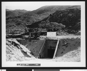 Construction of the Colorado River Aqueduct, showing a crane over a tunnel opening, ca.1930