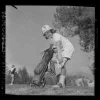 Seven year old Beverly Klass adjusting her shoe during competition in Los Angeles City Junior Golf Tournament, 1964