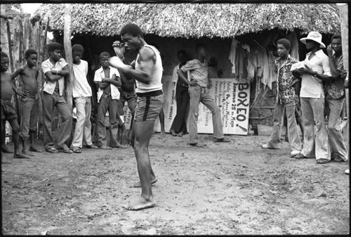 Man boxing outdoor in front of a crowd, San Basilio de Palenque, 1975