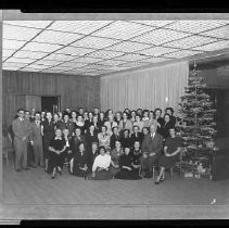 Group of people posed next to a Christmas tree