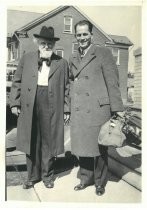Edwin Markham and unidentified man in front of brick house
