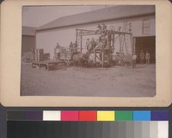 California Wine Association winery in Geyserville, California, with men posing on the crusher outside the building, about 1888