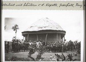 Catechist and pupils stand in front of a chapel in the Grassfields in French Cameroon