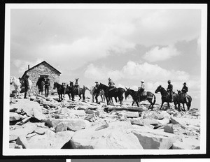 Men horseback riding in a rocky mountainous area, ca.1930