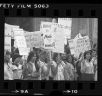 UCLA students with signs, one reading "Money for Minds not Bombs" during Veteran's Day teach-in on nuclear weapons in Los Angeles, Calif., 1981