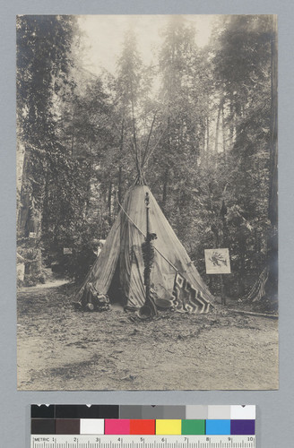 Tipi with baskets, blanket and cartoon of Native American, Bohemian Grove. [photographic print]