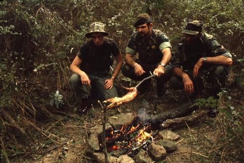 Harry Claflin and survival school students sit around a campfire, Liberal, 1982