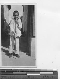 An orphan boy with a walking stick at Yangjiang, China, 1924