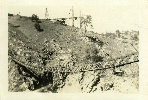 A suspended bridge at the Old Don Pedro Dam construction site, circa 1922