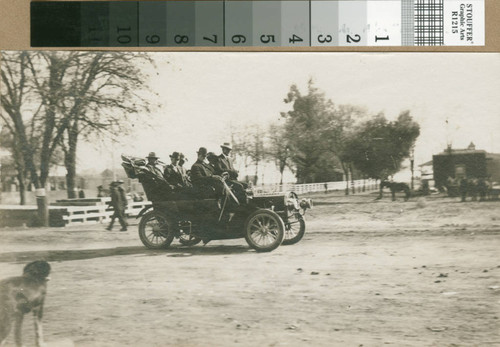 A group of men drive past the cemetery in a REO car in Turlock, California, circa 1907