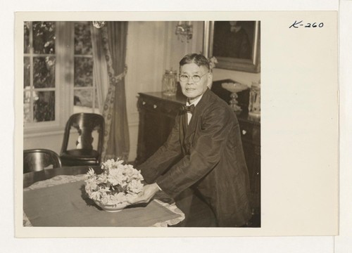 Mr. Yonekichi Nakata is shown arranging a bowl of flowers in the dining room of the Livingstone estate. Mr. Nakata