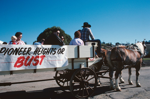 Slide of horse-drawn wagon with sign reading "Pioneer Heights or Bust."