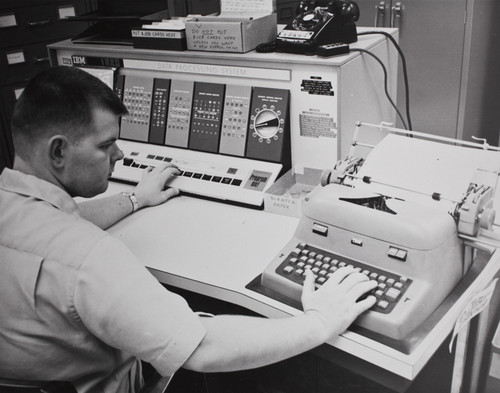 A man utilizing an IBM 1620 Data Processing System