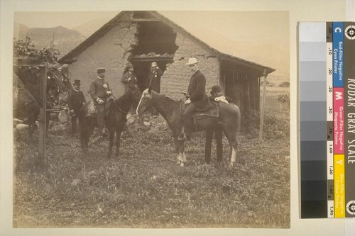 [Men at adobe ruin, some on horseback]