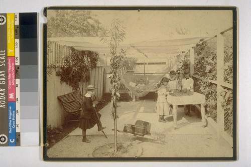 [Children playing in yard of Taber residence. Daisy Taber at right; Louise Taber in hammock? Photograph by Isaiah West Taber.]