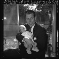 U.S. Congressman-elect John V. Tunney holding his 3 month old son, 1964