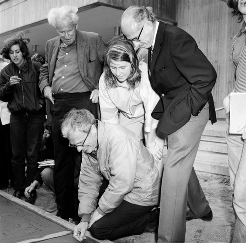 John Stewart writing name in cement with Jonas Salk and others watching, Muir College, UC San Diego