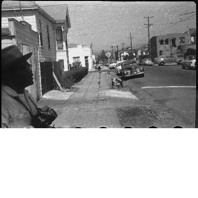 Man standing on sidewalk holding camera