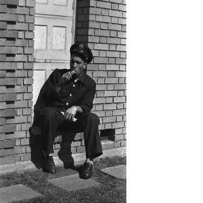 Oakland firefighter sitting in doorway eating Popsicle