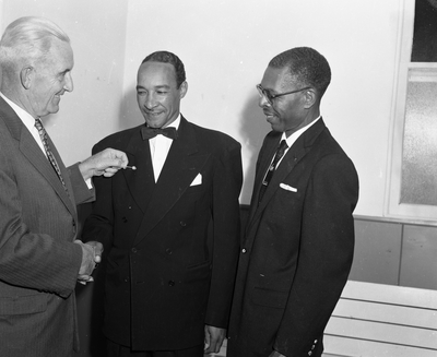 Al Fulcher (center) shaking hands with man