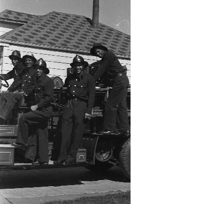 Group of Oakland firefighters standing on fire engine