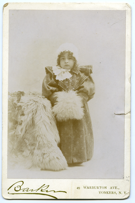 Portrait of boy in oversized coat and cap