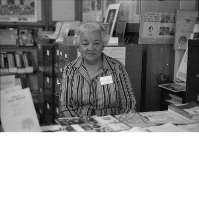 Hostess Marybelle Broussard sitting at desk at the East Bay Negro Historical Society