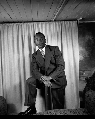 Portrait of man in suit with foot on sofa