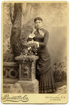 Portrait of woman leaning on cornerstone