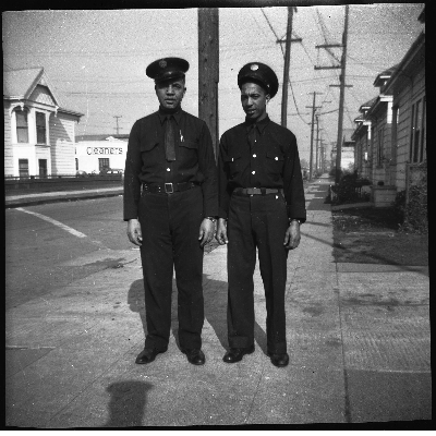 Two Oakland firefighters standing on sidewalk