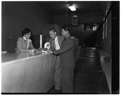 Two men talking with bank teller at Trans-Bay Federal Savings and Loan Bank