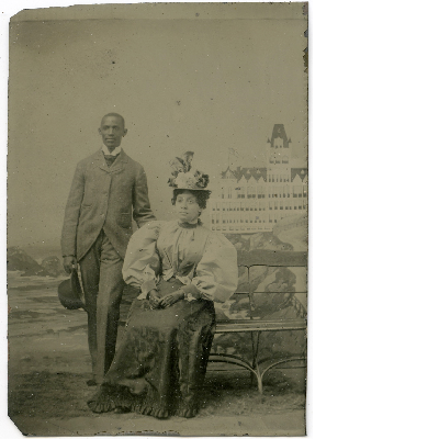 Portrait of unidentified man and woman standing in front of Cliff House backdrop