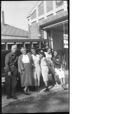 Man standing with five women in front of fire station