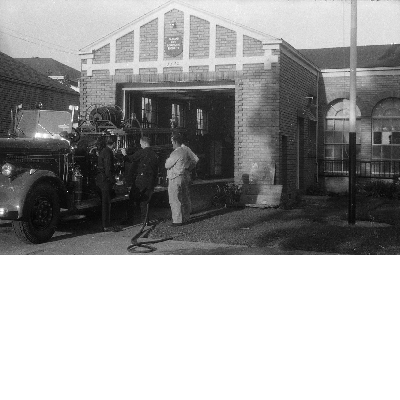 Oakland firemen standing next to fire truck in front of Oakland Fire Engine No . 22