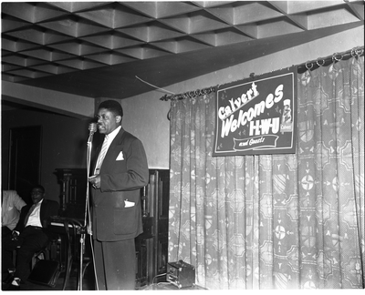 Man speaking at microphone in front of "Calvert welcomes ILWU and guests" banner