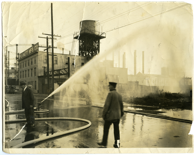 Fire hose on empty lot next to Planett Manufacturing Co