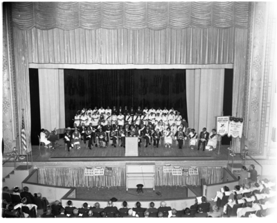 Aerial view of men and women seated on stage at the Prince Hall Golden State Grand Chapter meeting