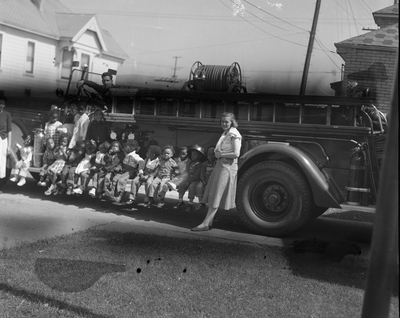 Group of children sitting on fire truck running board