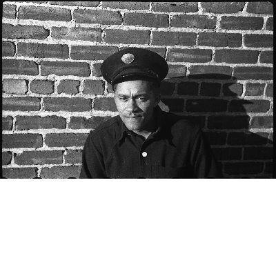 Oakland firefighter leaning against brick wall