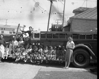 Children sitting on running board of fire truck