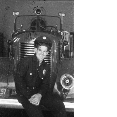 Oakland firefighter sitting on front bumper of fire engine