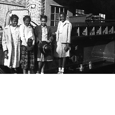 Four girls standing on fire engine