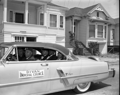 Masons riding in car with Divan Imperial Council banner