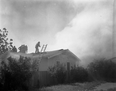 Firefighters on roof fighting house fire