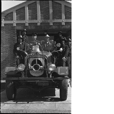 Group photograph of Oakland firefighters on fire truck in front of fire engine no. 22