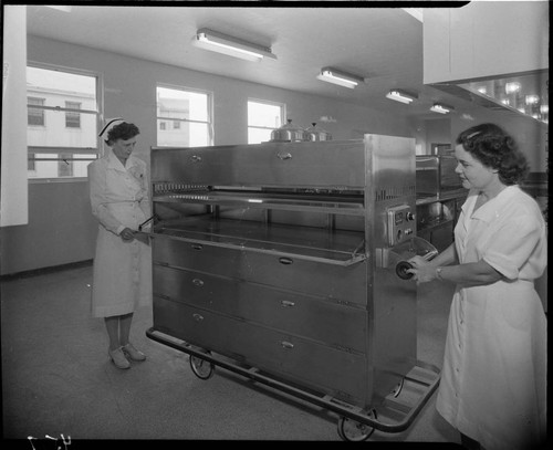 Nurse and a lady with what appears to be an electric food transport cart