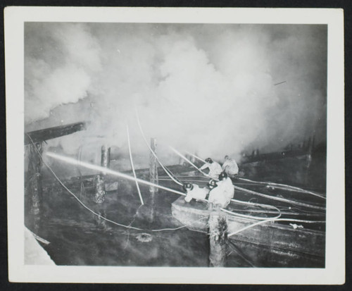 Five unidentified crew fighting a dock fire